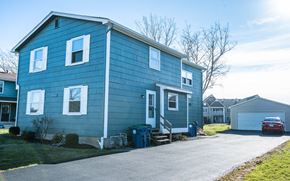 Amherst triplex for rent - a blue house with a car parked in front of it