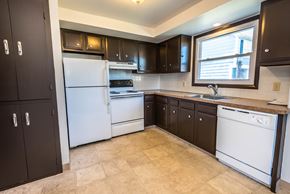 Amherst triplex for rent - a kitchen with white appliances and black cabinets and a window