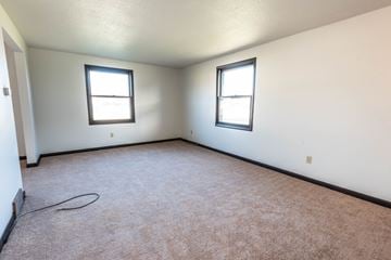 Amherst triplex for rent - the living room of a home with carpet and two windows