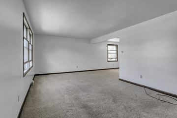 Amherst triplex for rent - the living room of a house with carpet and white walls