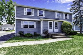 Amherst triplex for rent - a blue house with a sidewalk in front of it