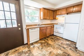 Amherst triplex for rent - an empty kitchen with white appliances and wooden cabinets
