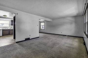 Amherst triplex for rent - the living room and kitchen of a new home with white walls and carpet