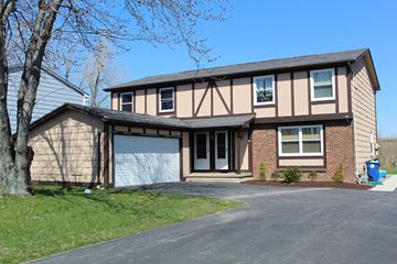 Amherst triplex for rent - a tan and brown house with a garage door