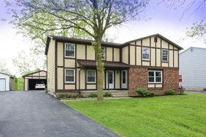 Amherst triplex for rent - A house with a driveway and a tree in front.