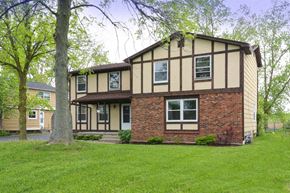 Amherst triplex for rent - A house with a brown and beige exterior and a white door.