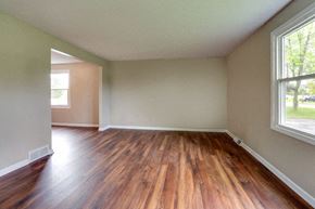 Amherst triplex for rent - A room with wooden floors and a window.
