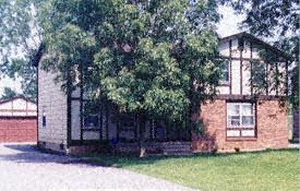 Amherst triplex for rent - A house with a red brick exterior and a white garage door.