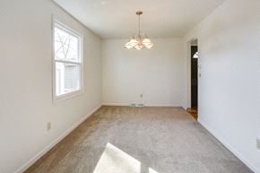 Amherst triplex for rent - A room with a carpet, a window, and a chandelier.