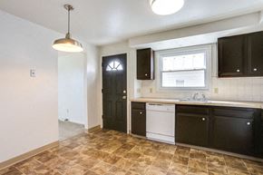 Amherst triplex for rent - A kitchen with black cabinets and a tiled floor.