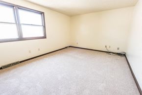 Amherst triplex for rent - A room with a carpeted floor and a window.
