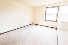 Amherst triplex for rent - A room with a carpeted floor and a window.