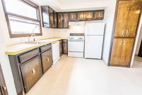 Amherst triplex for rent - an empty kitchen with white appliances and wooden cabinets
