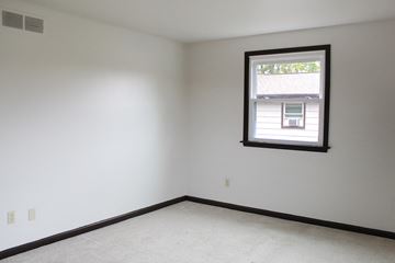 Amherst triplex for rent - a bedroom with a window and white walls