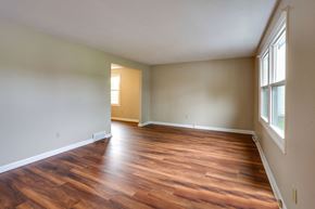 Amherst triplex for rent - an empty living room with wooden floors and a window