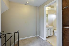 Amherst triplex for rent - a bedroom with a staircase and a bathroom with a toilet and sink