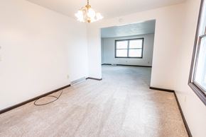 Amherst triplex for rent - the living room and dining room in a new home with white walls and carpet