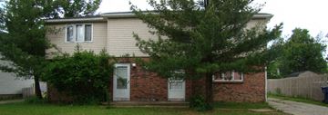 Amherst triplex for rent - A small house with a white door and a tree in front.