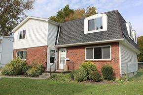 Amherst triplex for rent - A house with a red brick wall and a grey roof.