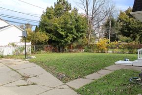 Amherst triplex for rent - A backyard with a basketball hoop and a white fence.