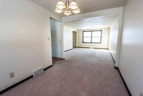 Amherst triplex for rent - A room with a carpeted floor and a window.