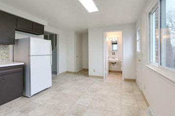 Cheektowaga triplex for rent - A kitchen with a white refrigerator and a tiled floor.
