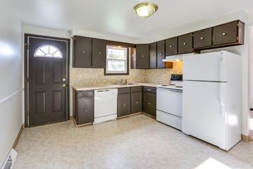 Amherst triplex for rent - an empty kitchen with white appliances and dark cabinets