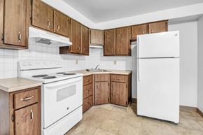 Amherst triplex for rent - A kitchen with white appliances and wooden cabinets.