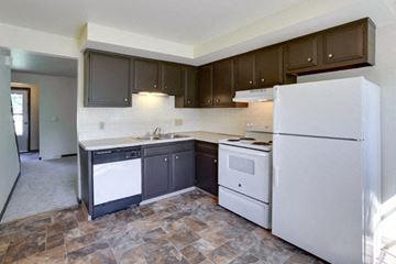 Amherst triplex for rent - A kitchen with a white refrigerator, black dishwasher, and white oven.