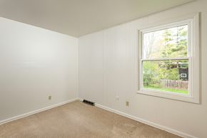Amherst triplex for rent - a bedroom with a large window and white walls