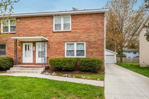 Amherst triplex for rent - a red brick house with a white door and a sidewalk