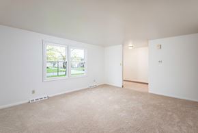 Amherst triplex for rent - the living room of an empty house with a large window
