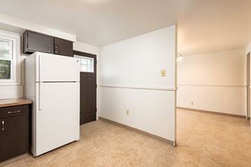 Amherst triplex for rent - a kitchen with a white refrigerator and a black door