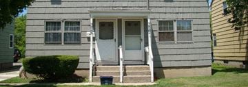 Buffalo triplex for rent - the front of a house with steps and a blue door