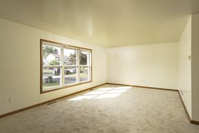 Amherst triplex for rent - the living room of a home with a large window and carpet