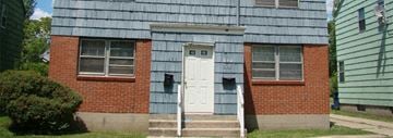 Buffalo triplex for rent - an old red brick house with a white door