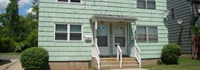 Buffalo triplex for rent - A green house with a white door and windows.