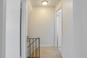 Amherst house for rent - A hallway with a carpeted floor and a metal railing.