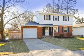 Amherst house for rent - A white house with a brick facade and a grey garage door.