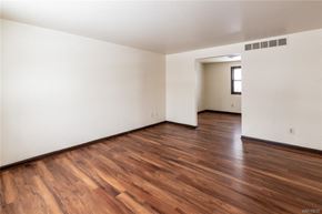 Amherst triplex for rent - an empty living room with white walls and wood floors