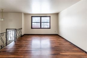 Amherst triplex for rent - an empty living room with wood floors and a window