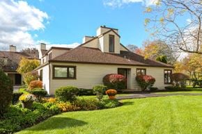 East Amherst condo for rent - A house with a well-kept lawn and a variety of plants in front.