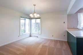 East Amherst condo for rent - A room with a carpeted floor and a window with a view of trees.
