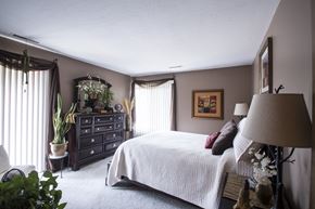 Canton townhouse for rent - a bedroom with a bed and a dresser and windows