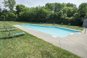 Canton apartment for rent - a swimming pool in the grass with chairs around it