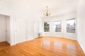 San Francisco apartment for rent - an empty living room with a wood floor and a chandelier