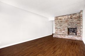 San Francisco apartment for rent - an empty room with a brick fireplace and wooden floors
