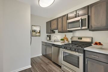 Lancaster apartment for rent - A kitchen with a stove top oven and microwave above it.
