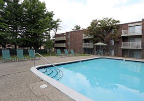 Philadelphia apartment for rent - A swimming pool surrounded by chairs and trees in front of apartment buildings.