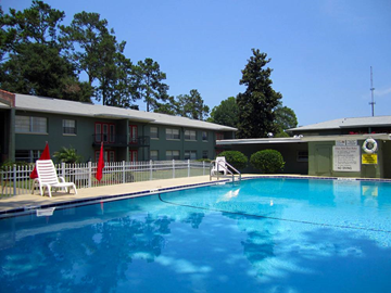 Gainesville apartment for rent - a large swimming pool in front of a building